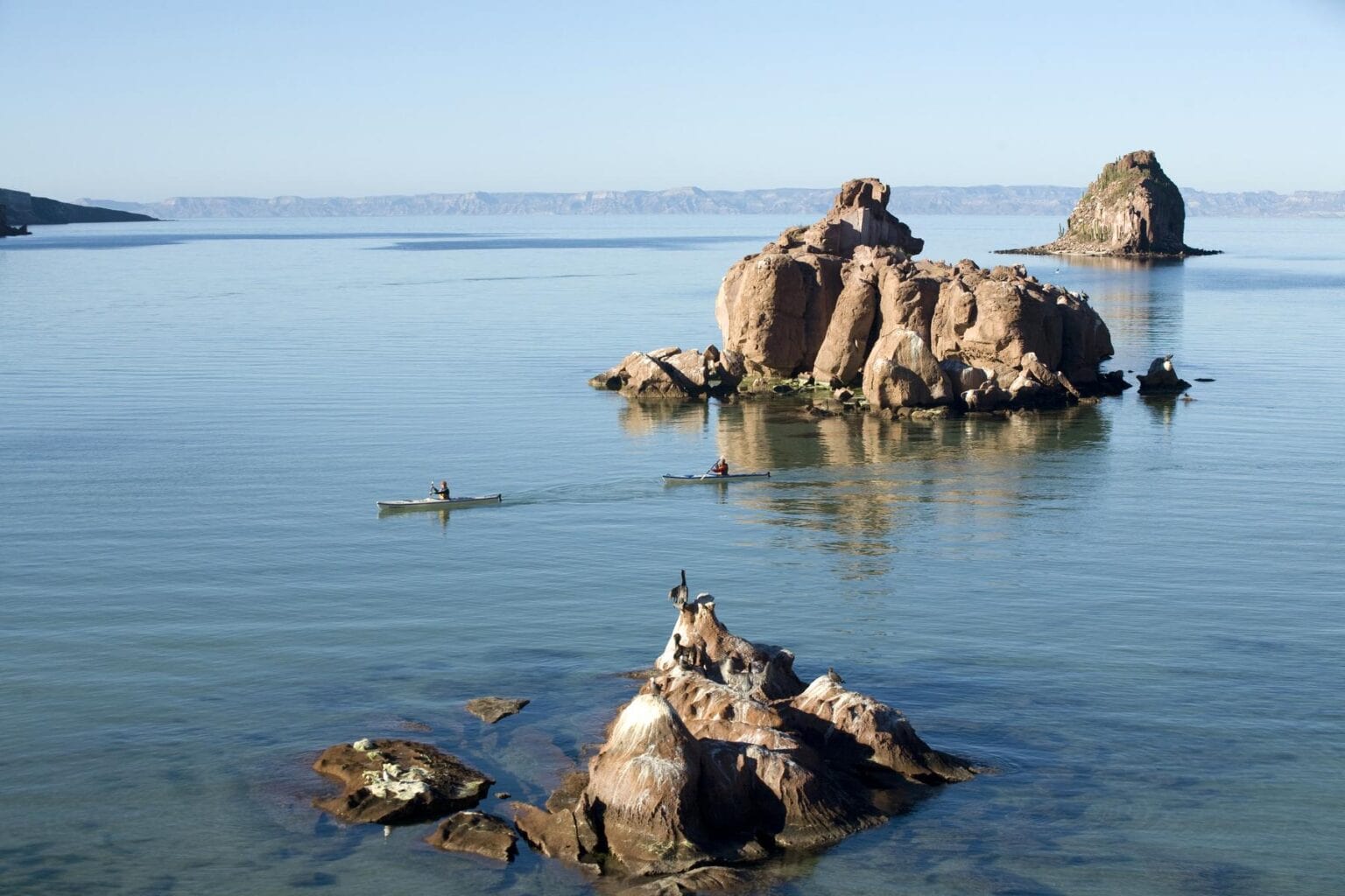 Two young women paddle sea kayaks in the Sea of Cortez in Baja, Mexico