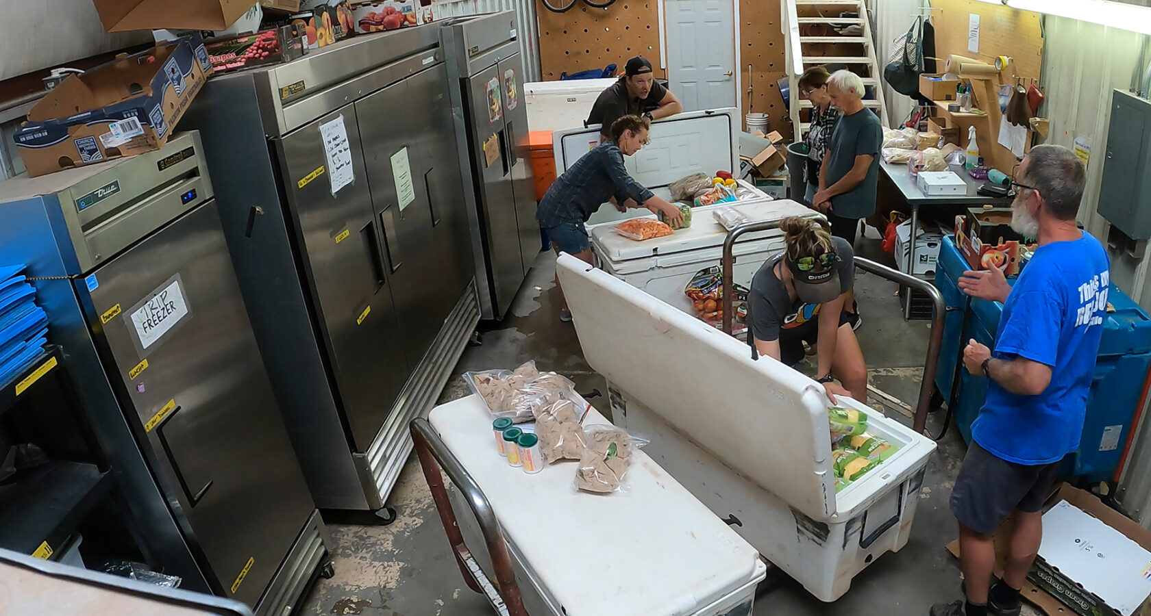 A group of people work together to pack large YETI coolers for a Grand Canyon rafting trip