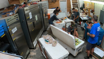 A group of people work together to pack large YETI coolers for a Grand Canyon rafting trip