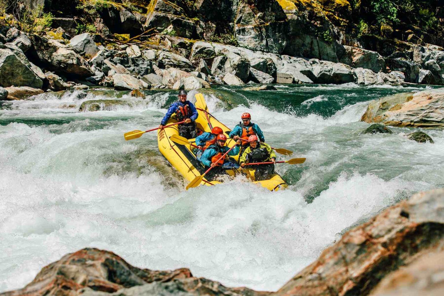 A group of guides in training rafts the American River.
