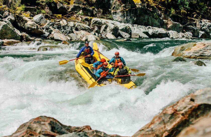 A group of guides in training rafts the American River.