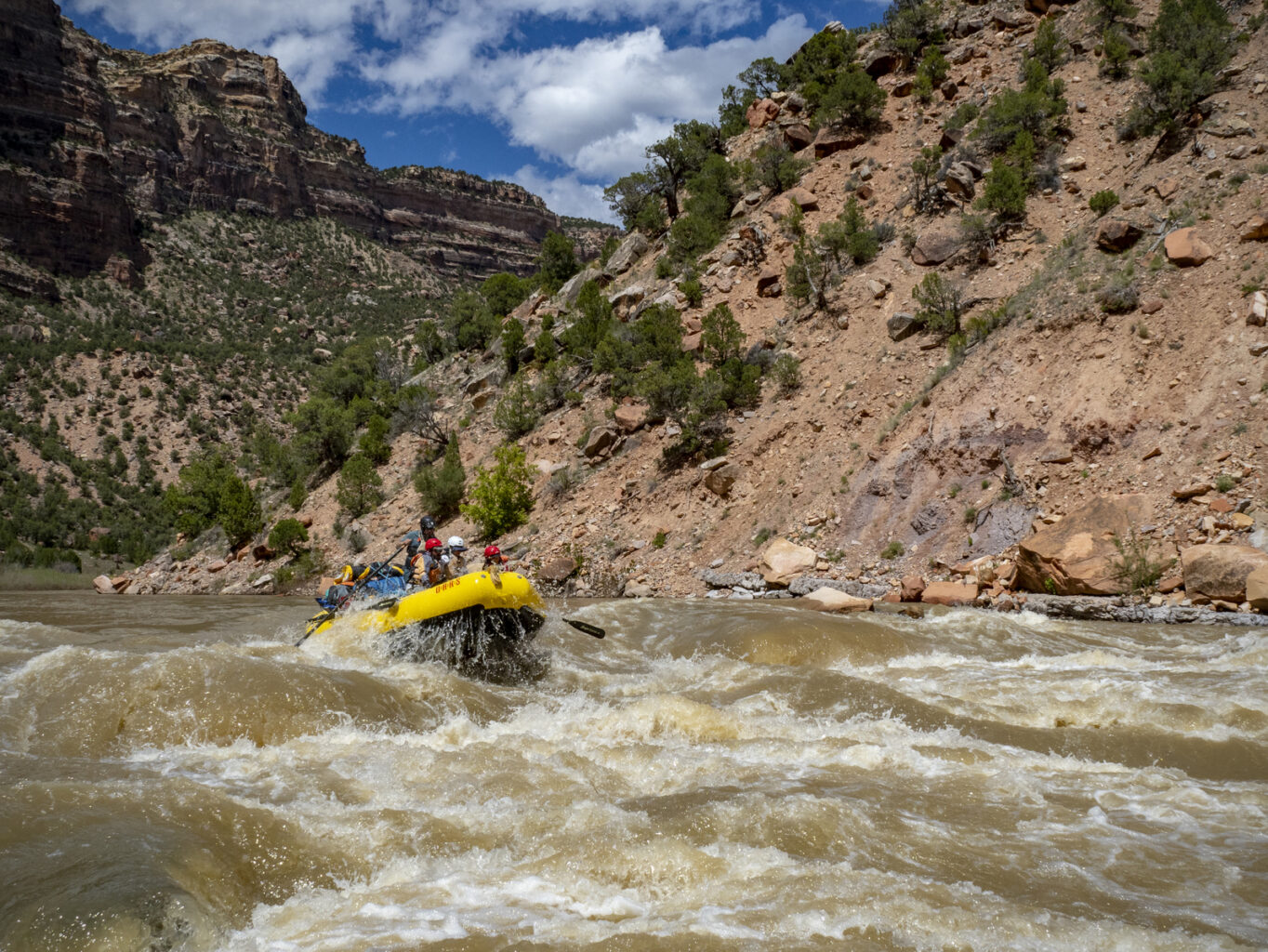 A raft full of people goes through a rapid on the Yampa River in Dinosaur National Monument in Utah