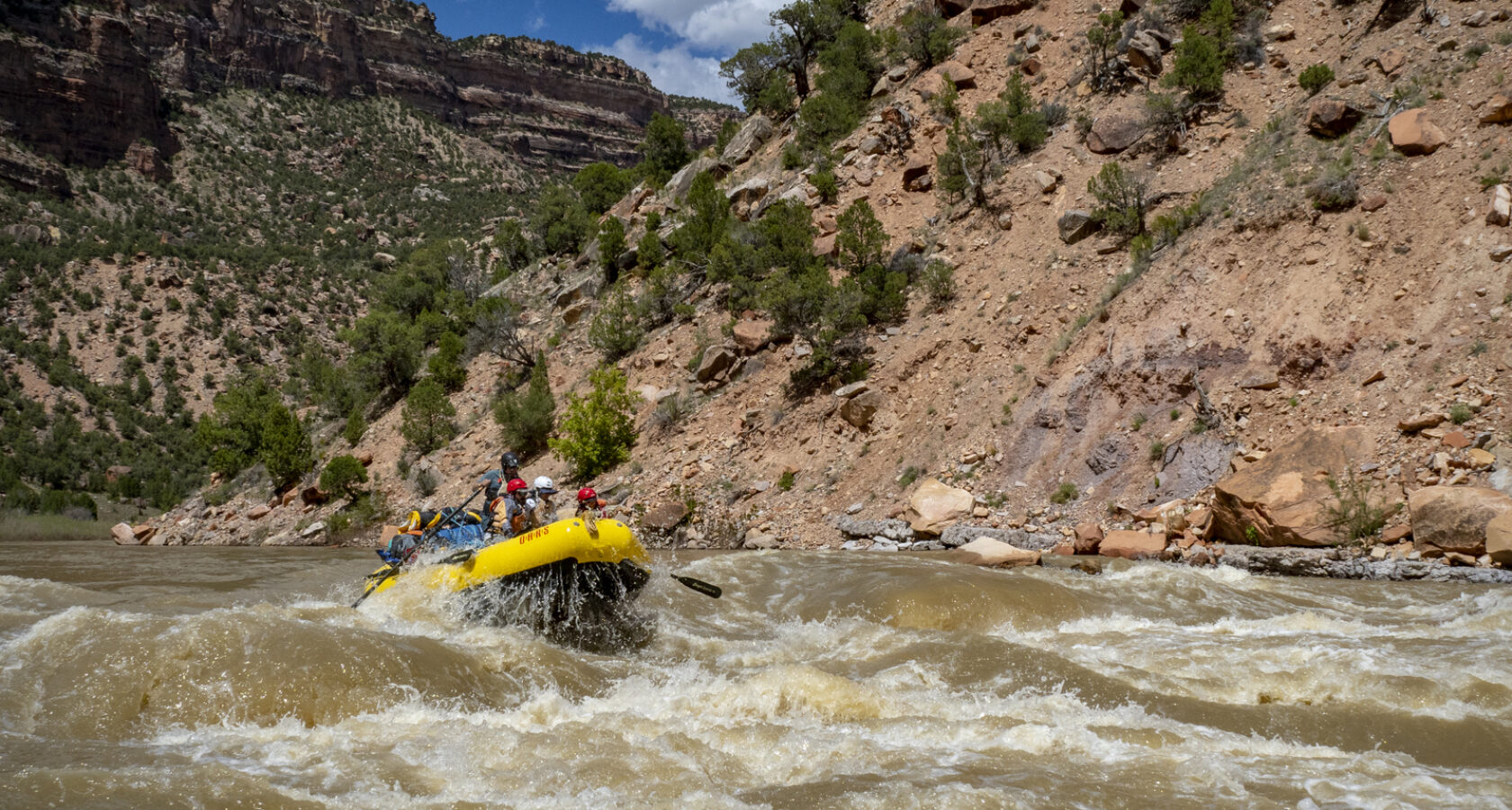 A raft full of people goes through a rapid on the Yampa River in Dinosaur National Monument in Utah