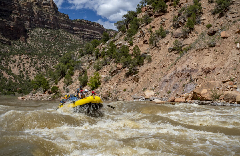 A raft full of people goes through a rapid on the Yampa River in Dinosaur National Monument in Utah