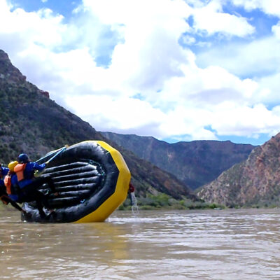 Three guides practice correcting a flipped raft during Dinosaur Whitewater Guide School training