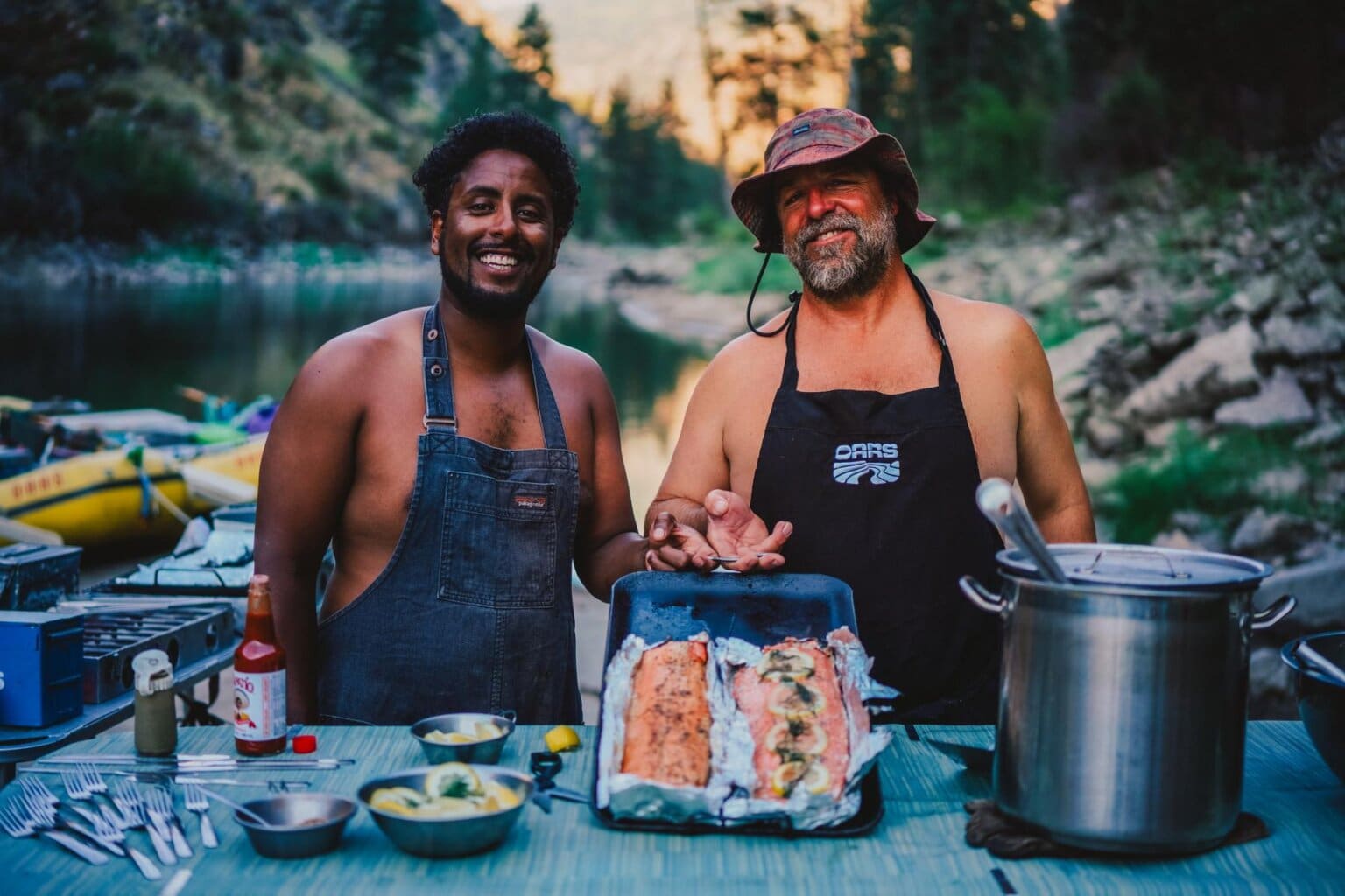 A pair of OARS guides show a salmon dinner they cooked on the Main Salmon River in Idaho