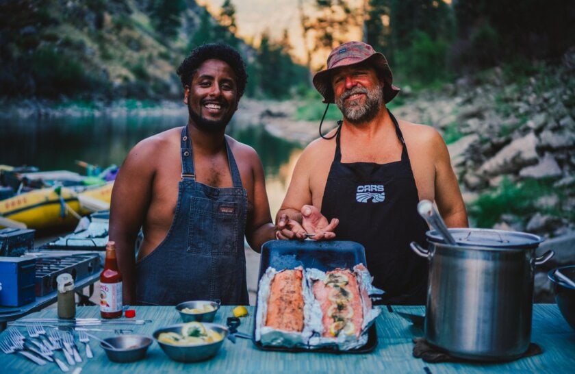A pair of OARS guides show a salmon dinner they cooked on the Main Salmon River in Idaho