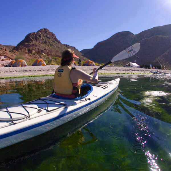 A person paddles a single kayak near the shore of Baja's Espiritu Santo