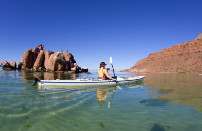 A solo sea kayaker paddles through the ocean waters of Baja Mexico