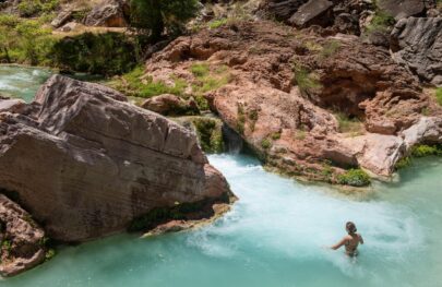 A woman wades in Havasupai Creek on an OARS Grand Canyon trip