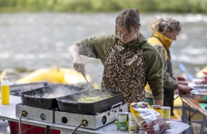 Two guides cooking on the side of the Klamath River during a three-day rafting trip with OARS in 2025.