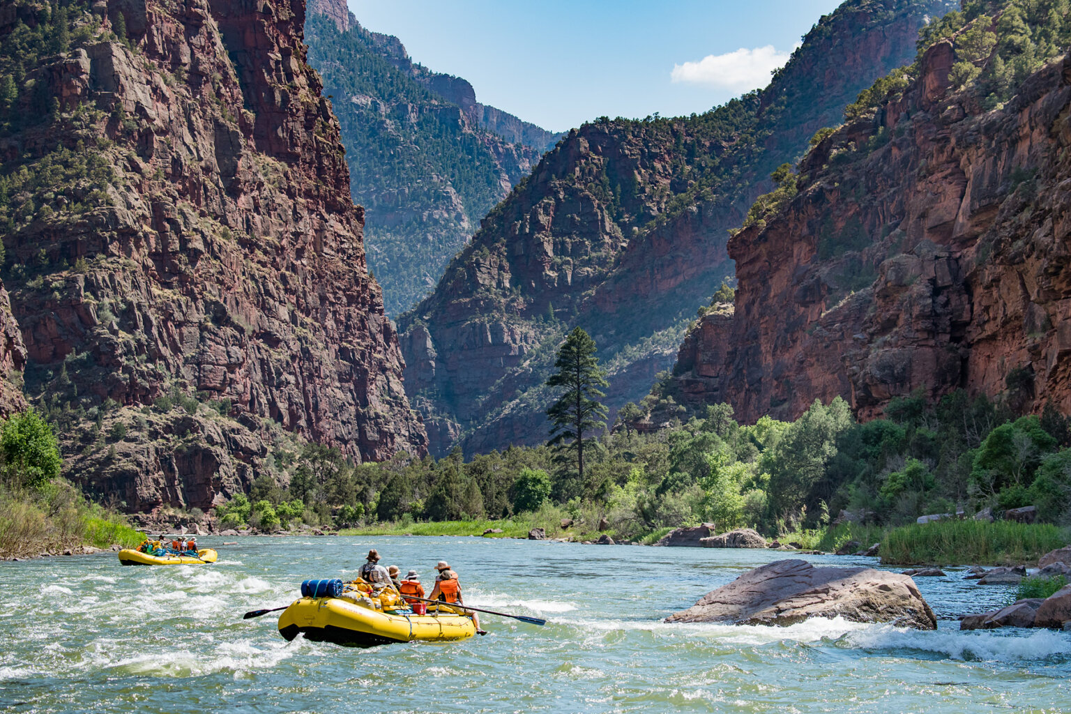 Two yellow OARS rafts full of people on the Green River through the Gates of Lodore.