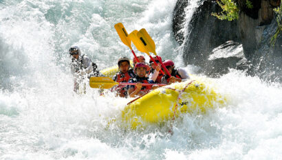 A yellow raft full of paddlers surrounded by frothy whitewater on the Middle Fork of the American River in California