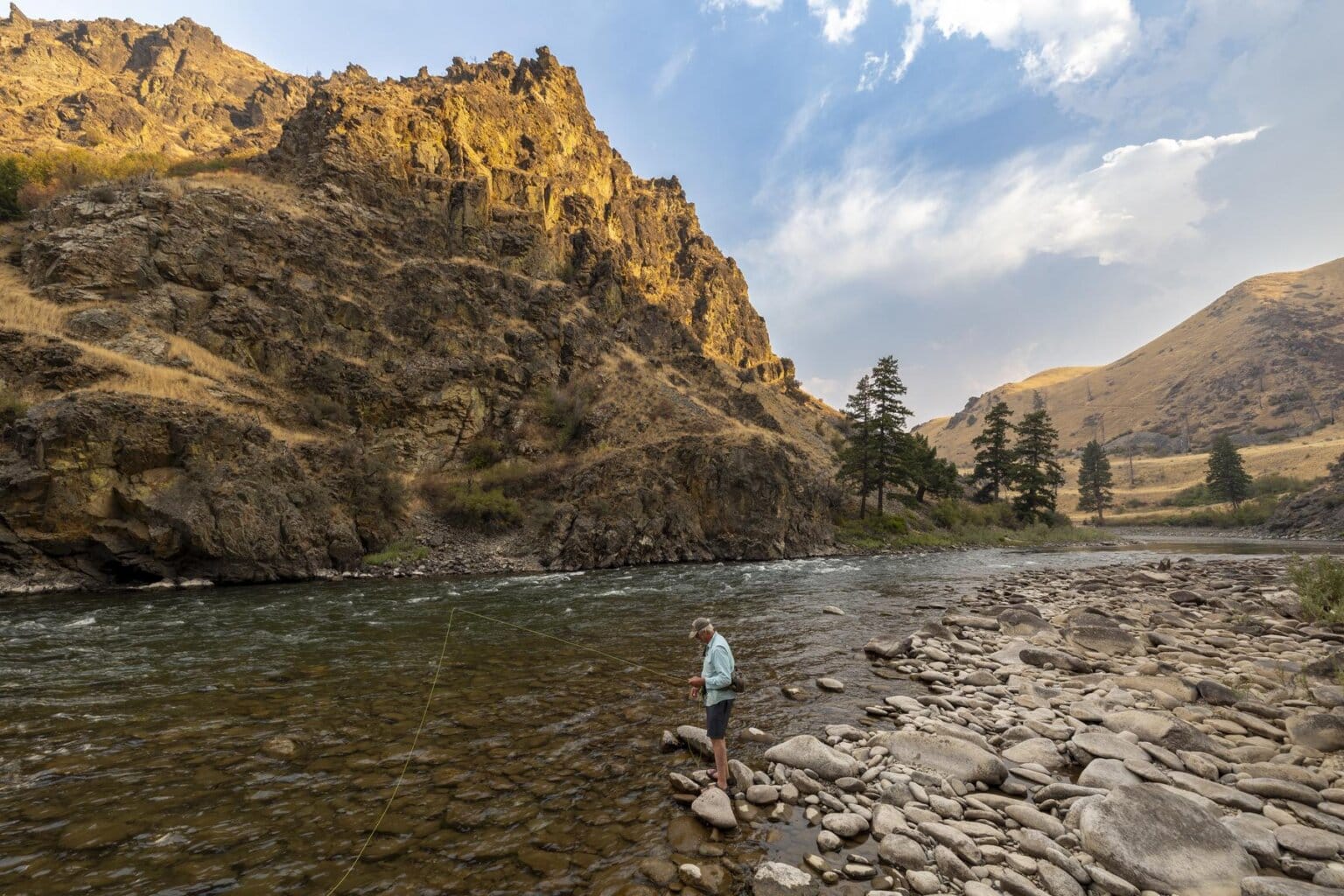 A fly fisherman near the edge of the Middle Fork Salmon River in Idaho.