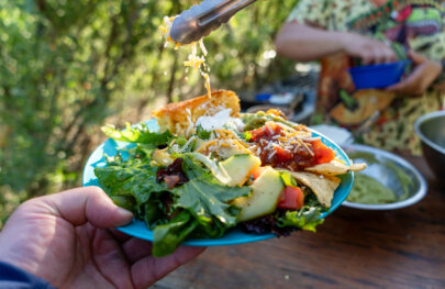A person holds up a meal on an OARS rafting trip on the Rogue River.