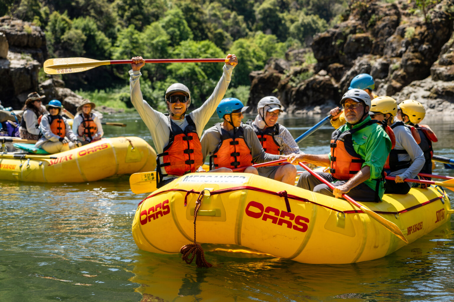 A rafter holds us his paddle in celebration during an OARS rafting trip on the Rogue River in June 2025.