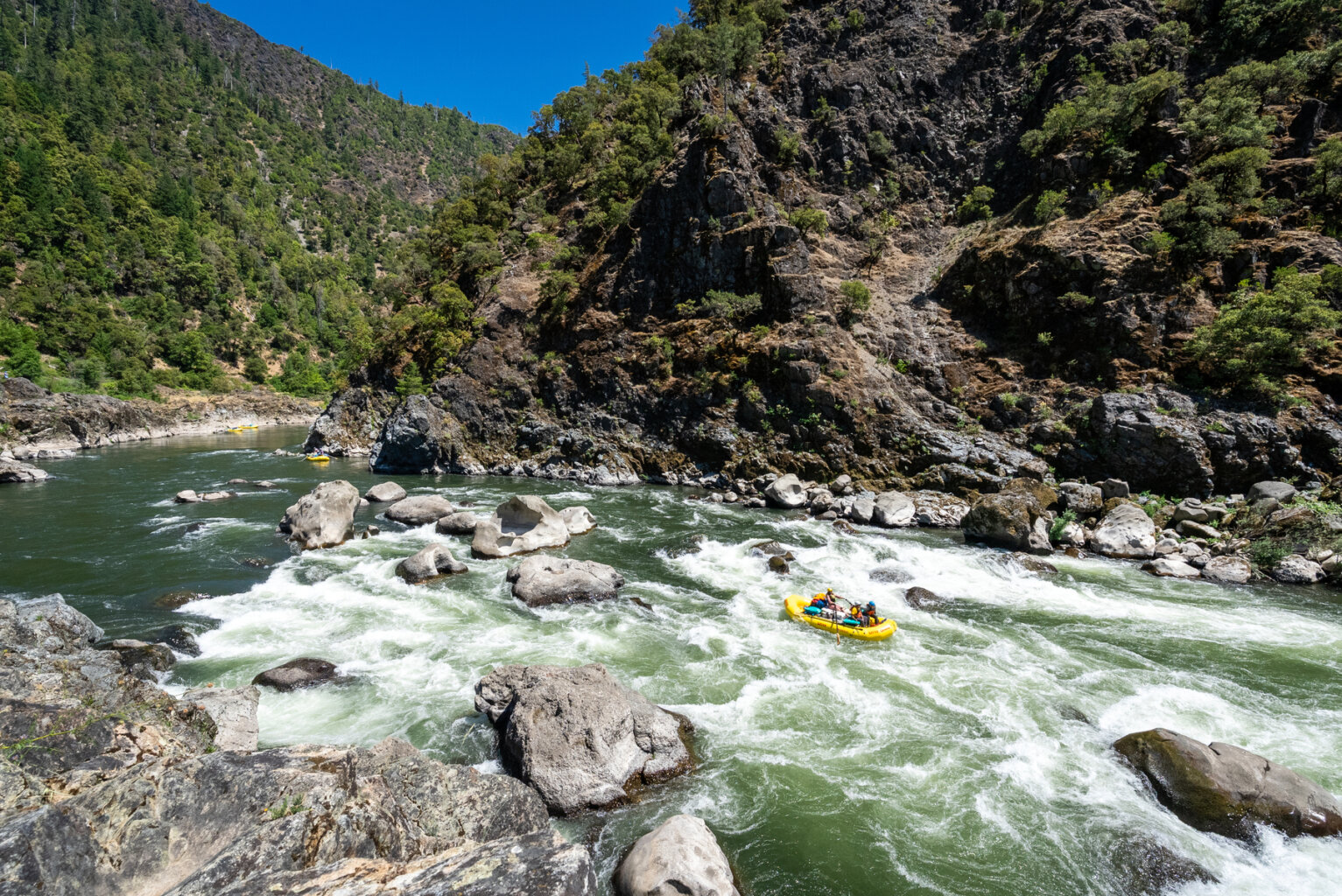 A raft makes its way through Blossom Bar rapid on the Rogue River in Oregon during an OARS rafting trip.