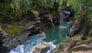 Two paddle rafts with guests head towards a rapid on the Upper Navua river with the rainforest above them.