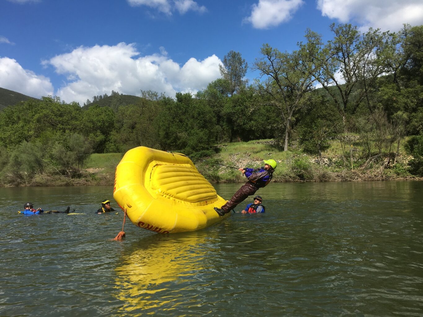 A raft guide in training flips a yellow raft on the South Fork of the American River.