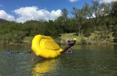 A raft guide in training flips a yellow raft on the South Fork of the American River.