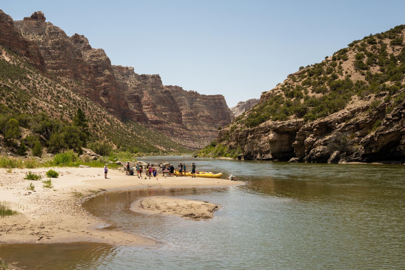A group of rafters stop for lunch on a sand bar near the Green River during a rafting trip with OARS in 2025.