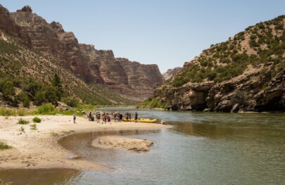 A group of rafters stop for lunch on a sand bar near the Green River during a rafting trip with OARS in 2025.