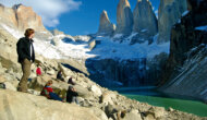 Guests sit on a rocky hillside during a hike and take in the view in Patagonia Chile.