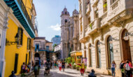 A bustling street in Cuba with vibrant and historical buildings.