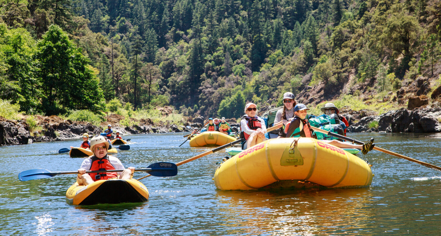 A group of rafters float down the Rogue River in Oregon on a multi-day trip with OARS