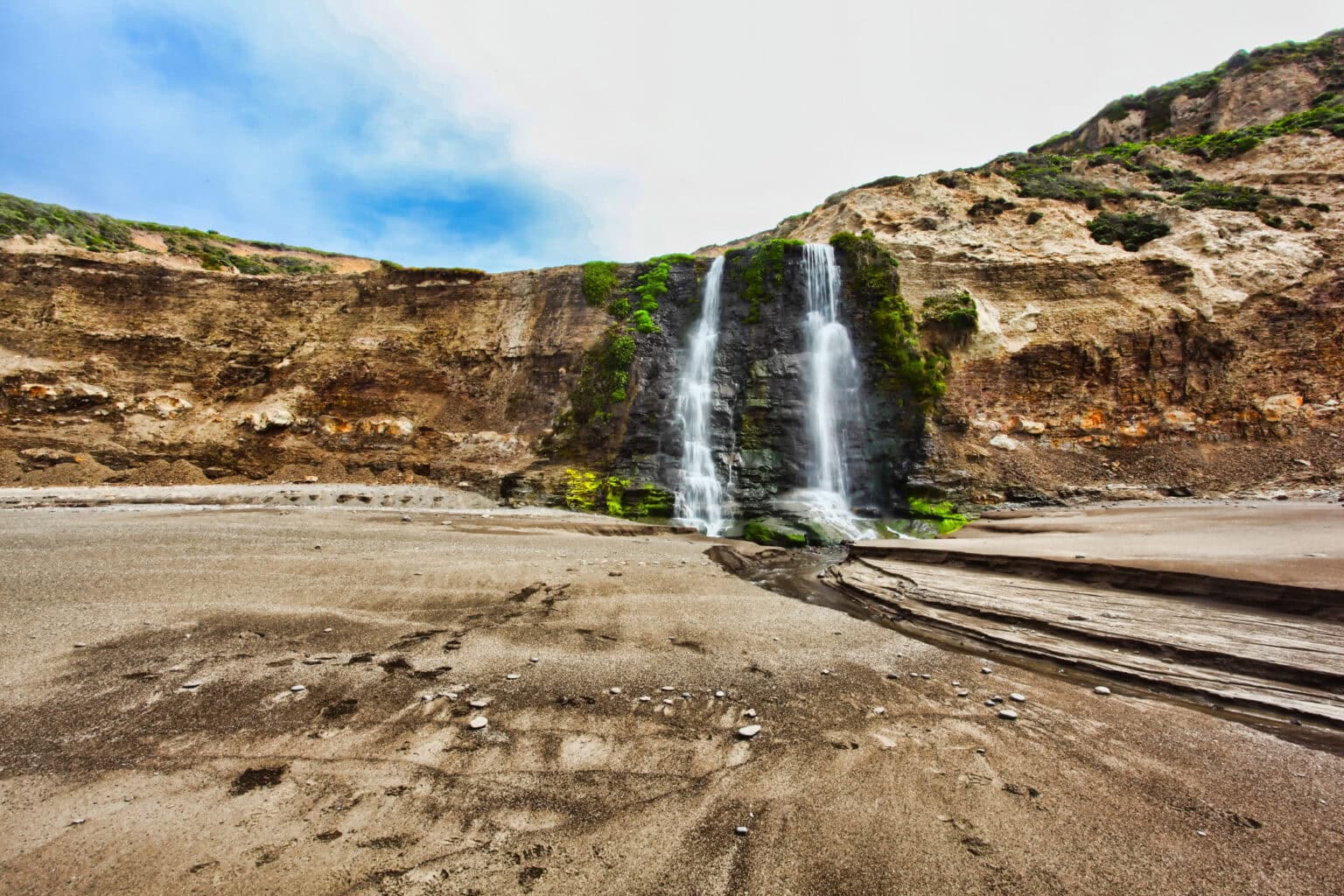 A waterfall spills onto a beach along Point Reyes National Seashore, the perfect adventure from San Francicso