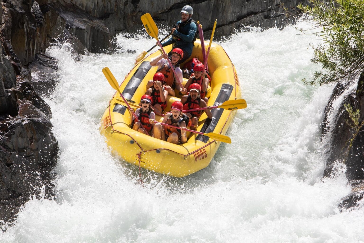 A group of rafters navigating a thrilling whitewater chute on the Middle Fork of the American River, one of the best California whitewater trips