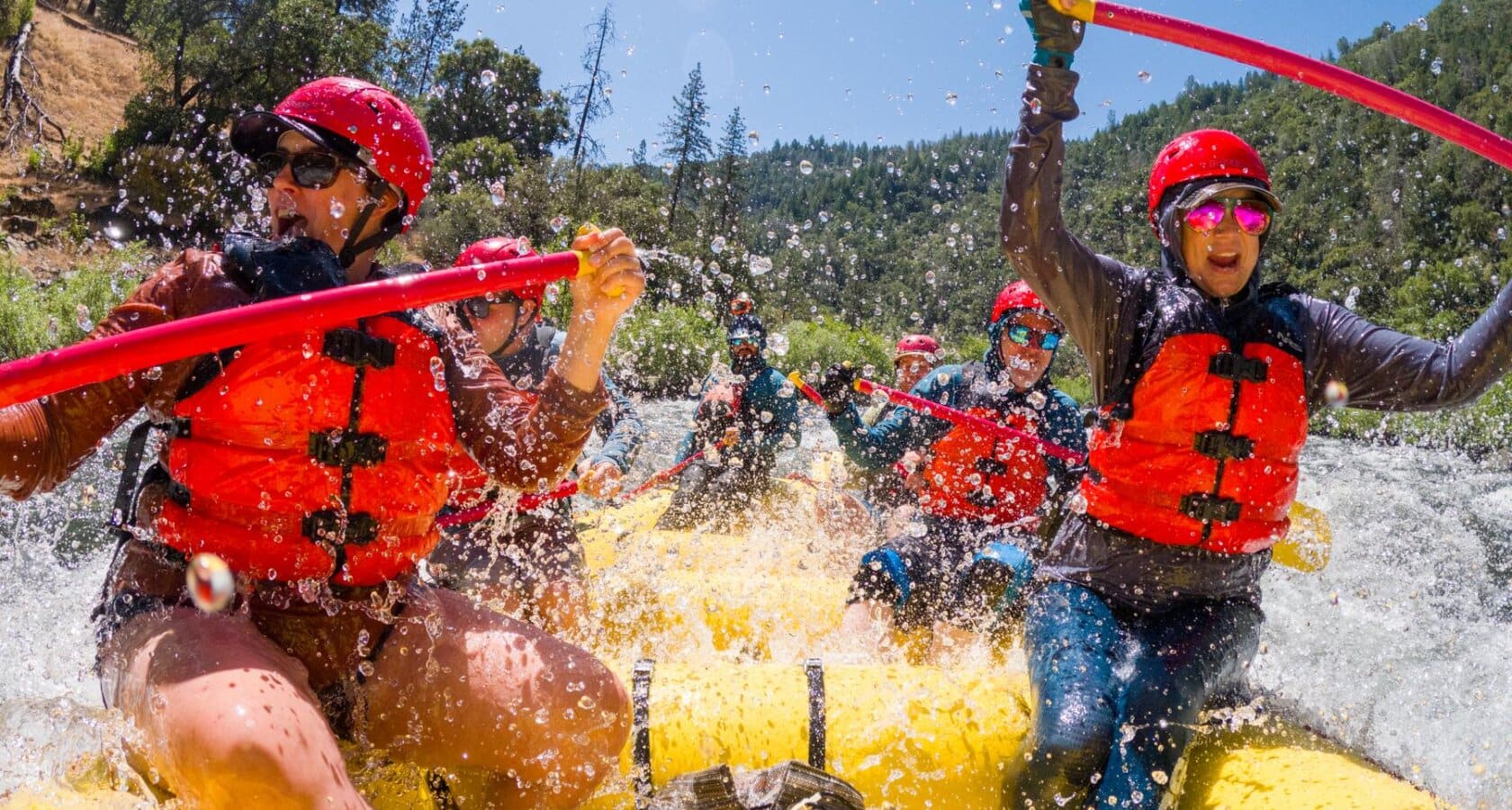 A raft full of people being splashed by whitewater