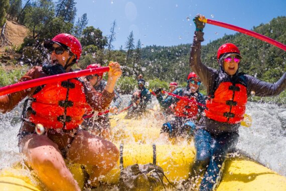 A raft full of people being splashed by whitewater