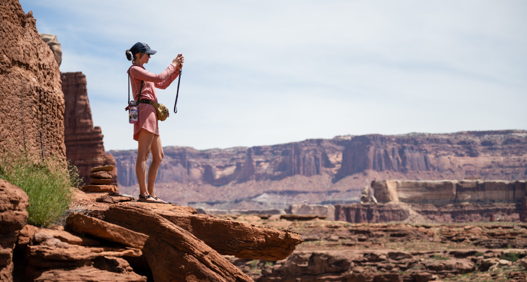Woman taking a photo from an overlook in Canyonlands National Park