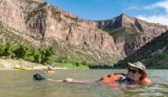 Woman in a PFD floating on her back in the Green River