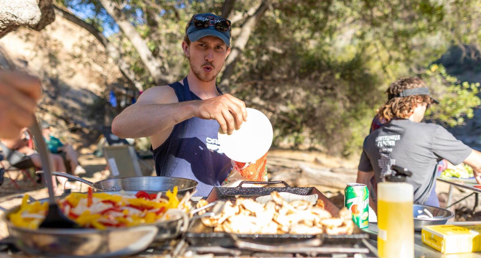 Man making fajitas in a camp kitchen set-up outside