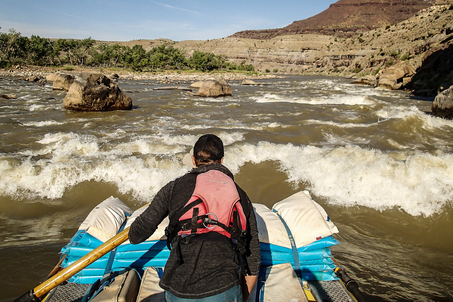 A guide stands to check their lines as they're about to enter a long rapid.