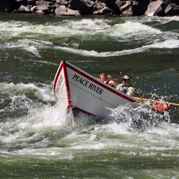 A man rowing a dory slices through whitewater on Idaho's Lower Salmon River