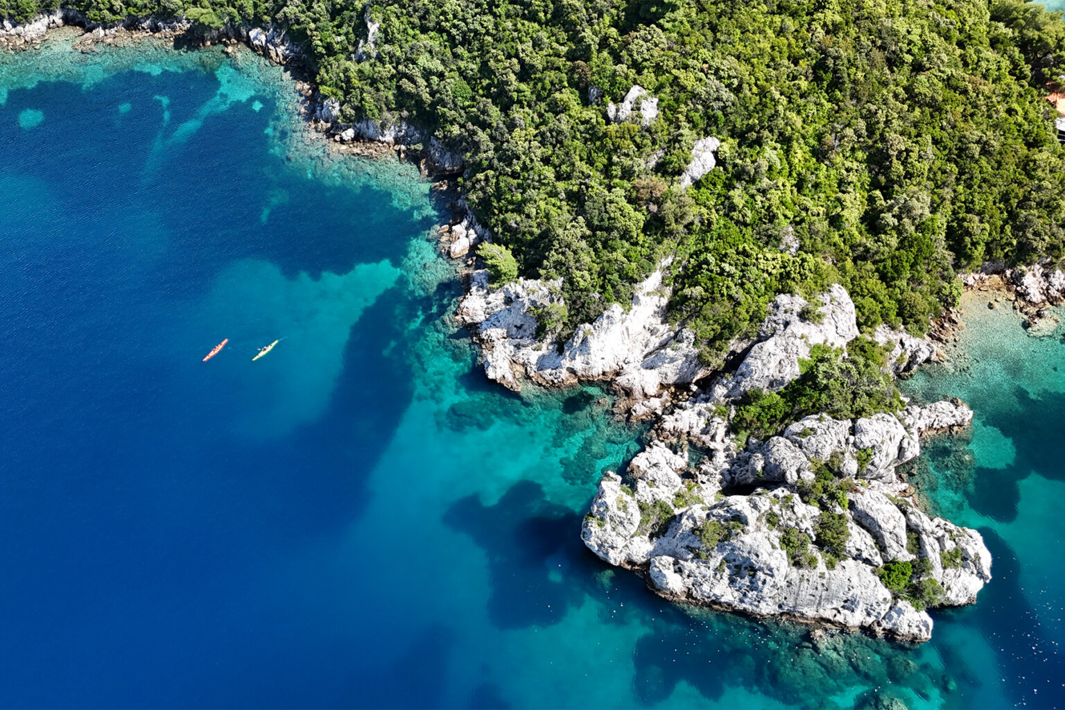 Two kayakers paddling the craggy coastline of Croatia's Elaphiti Islands