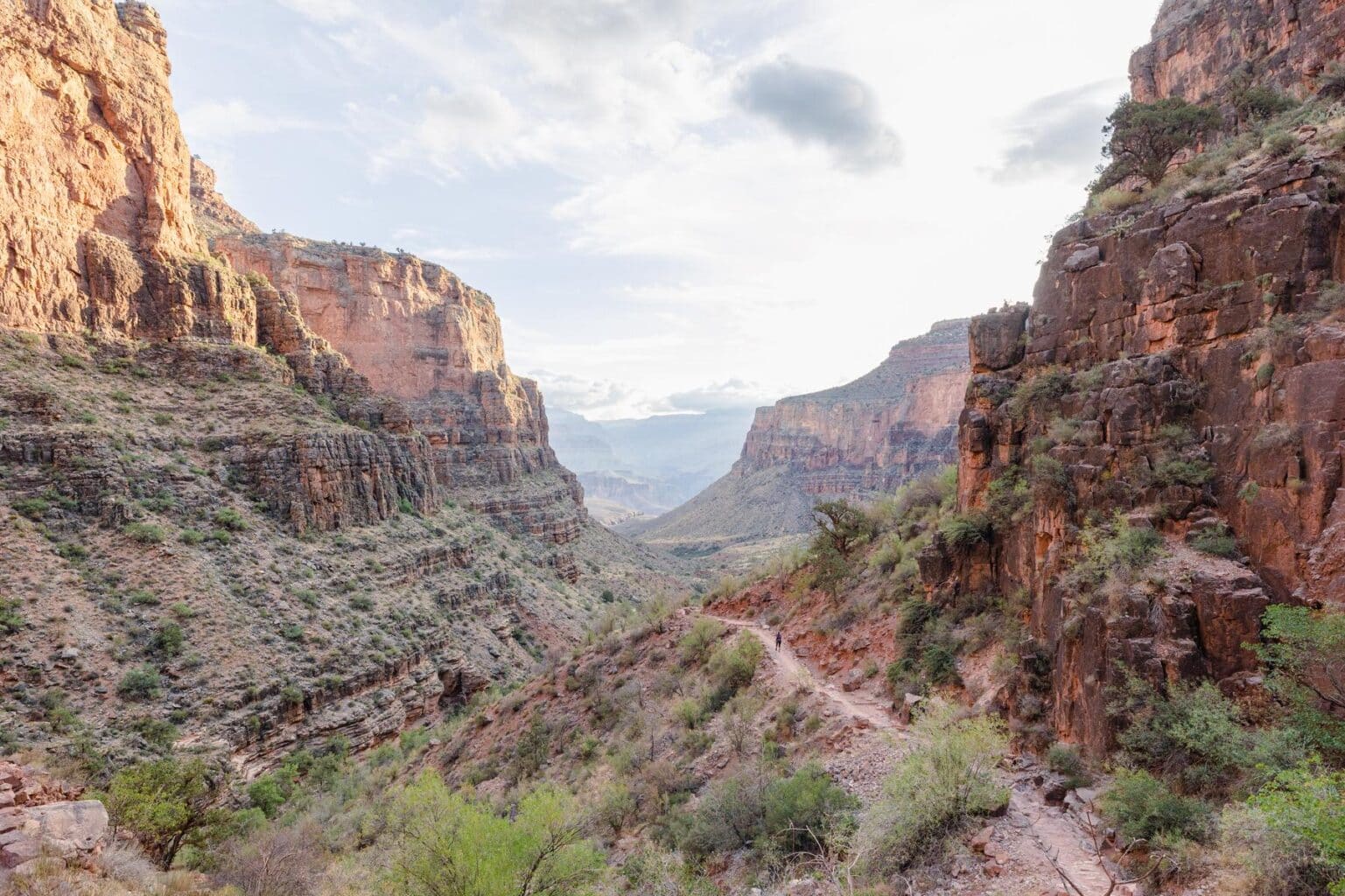 A hiker descends the Bright Angel Trail through Vishnu and Granite rock in Grand Canyon 