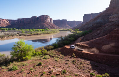 A van with a boat hitched to the back drives the road to the Mineral Bottom put-in on the Colorado River