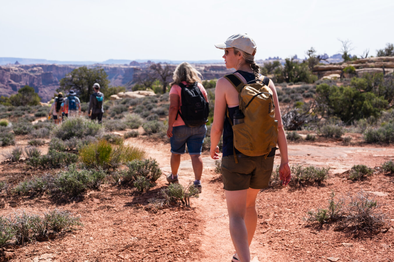 A group of hikers walk along a desert trail on an OARS Stillwater and Cataract Canyon hiker trip
