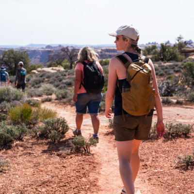 A group of hikers walk along a desert trail on an OARS Stillwater and Cataract Canyon hiker trip