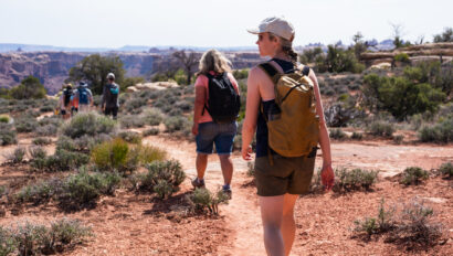 A group of hikers walk along a desert trail on an OARS Stillwater and Cataract Canyon hiker trip