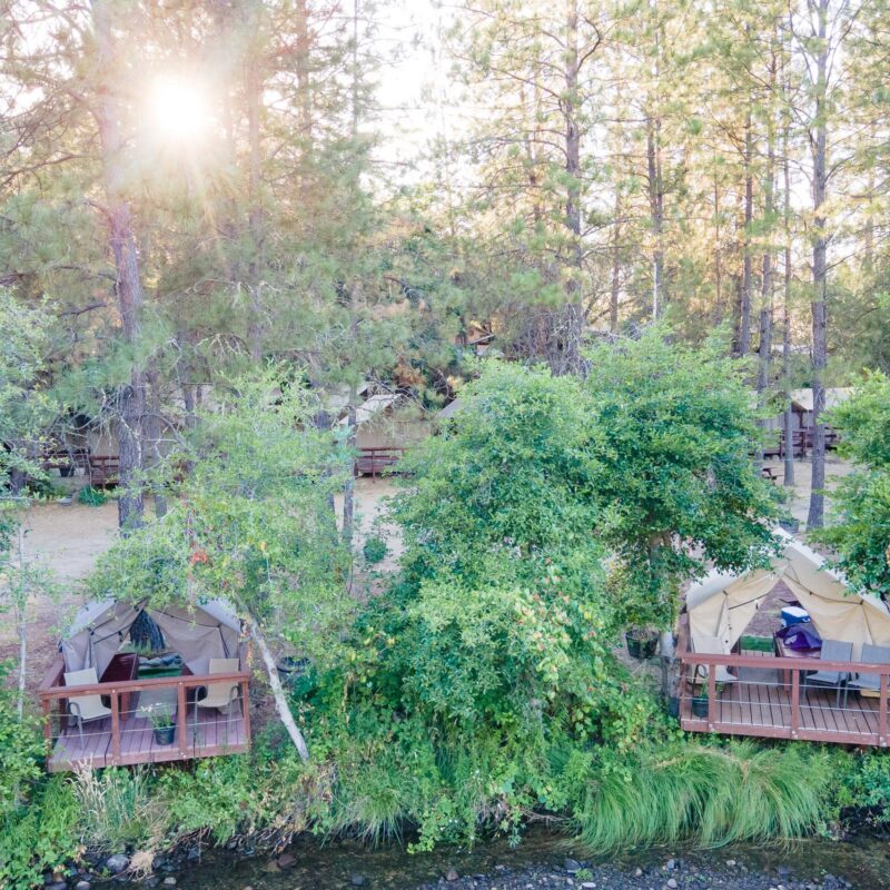 A tent by the river at the OARS at EarthTrek camp