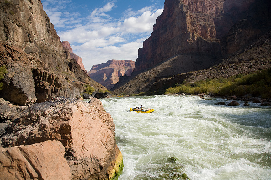 A single yellow raft running Lava Falls on the Colorado River in Grand Canyon