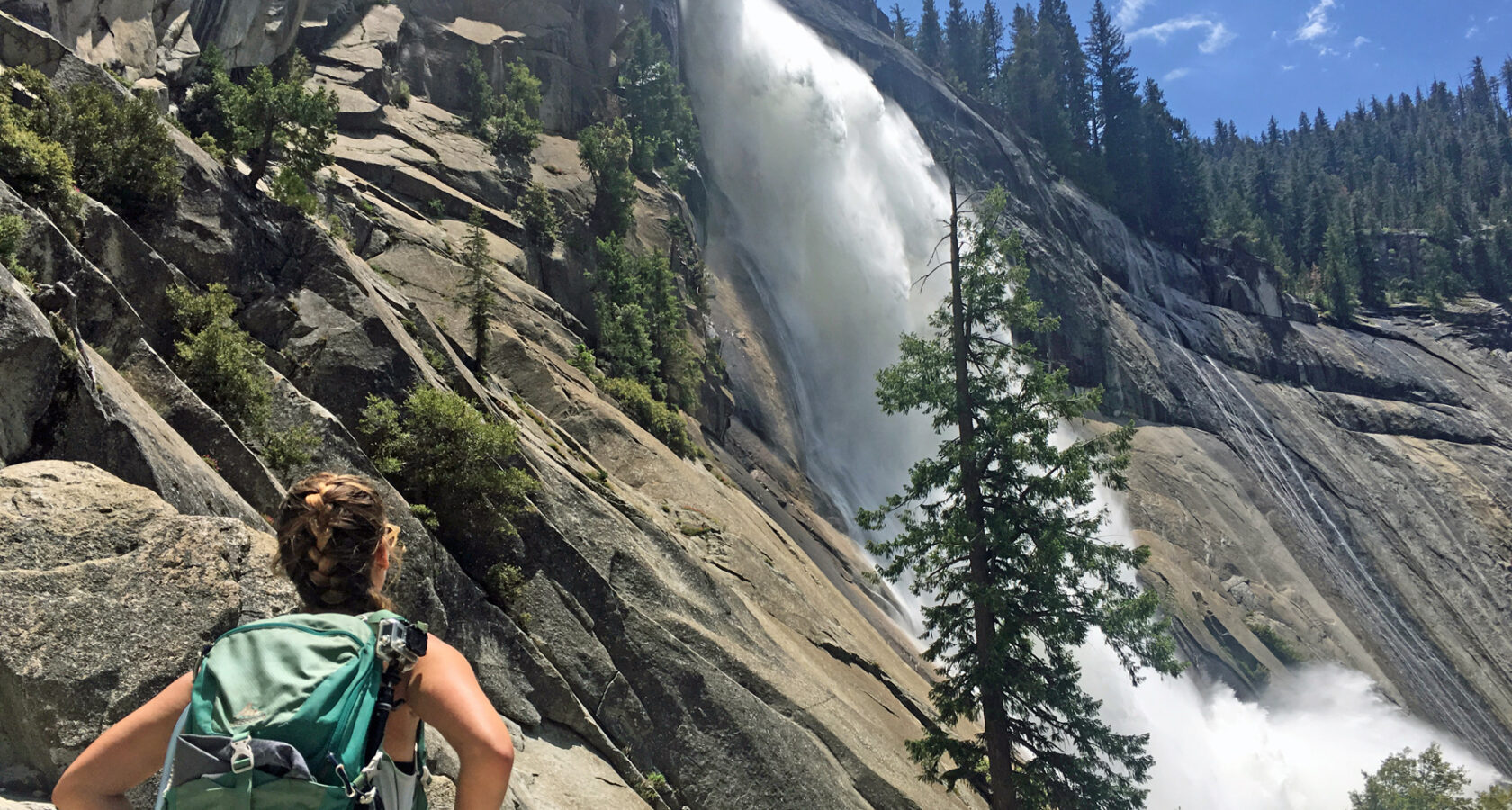 Woman appreciating a waterfall in Yosemite National Park