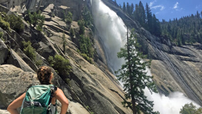Woman appreciating a waterfall in Yosemite National Park