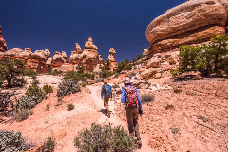 Two hikers approaching the Doll House area of Canyonlands National Park