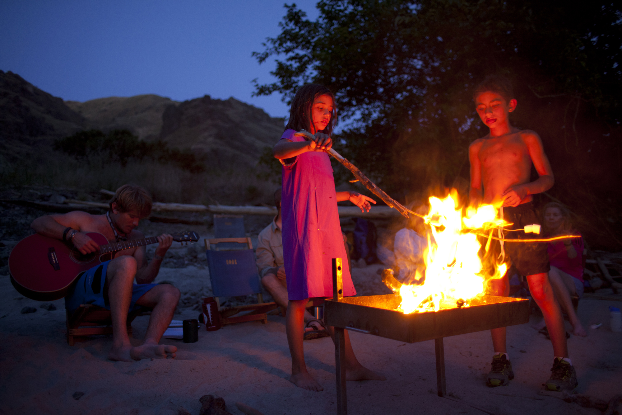 Children at a campfire on an unplugged vacation with their family
